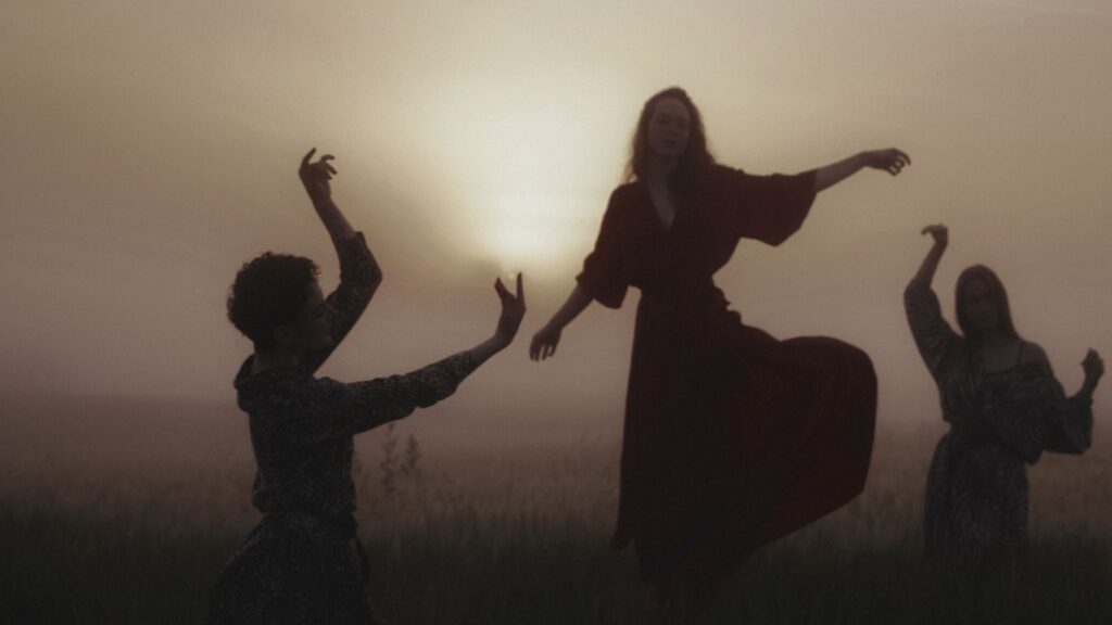Frauen die im Kreis tanzen bei untergehender Sonne spirituelle Unternehmerinnen